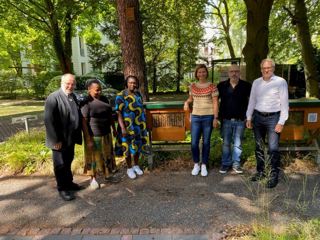 Die stellvertretende Geschäftsführerin der Hilfswerk-Siedlung GmbH, Dorit Brauns (3 v.r.), begrüßte mit zwei Vertretern der Bienengruppe (rechts) Pfarrerin Peris Thumbi (3. v.l.).